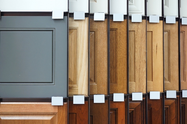 Many different wood kitchen cabinet panels are on display to show the variety of options.