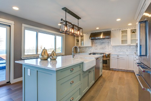 An immaculate kitchen includes a kitchen island that helps provide more counter space. 